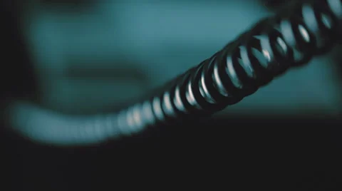 In the dim light the camera moves along the twisted wires from the handset Stock Footage 56259882