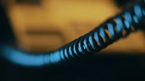 In the dim light, follow focus from black buttons to a telephone coiled cord Stock Footage 56258950