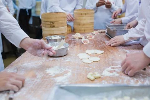 Dim Sum chefs working wrapping dumplings at famous restaurant in Taiwan. Stock Photos