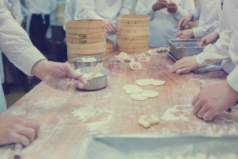 Dim Sum chefs working wrapping dumplings at famous restaurant in Taiwan. Stock Photos