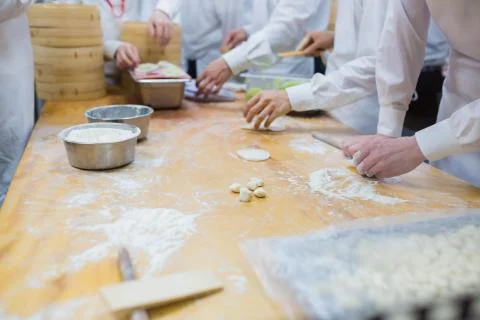 Dim Sum chefs working wrapping dumplings at famous restaurant in Taiwan. Stock Photos