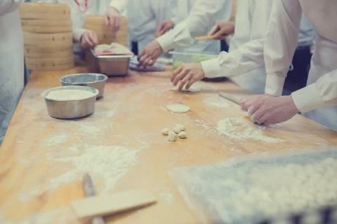 Dim Sum chefs working wrapping dumplings at famous restaurant in Taiwan. Stock Photos