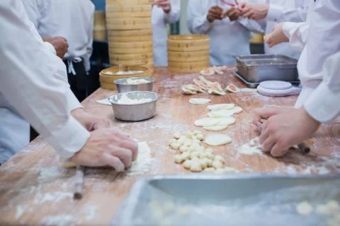 Dim Sum chefs working wrapping dumplings at famous restaurant in Taiwan. Stock Photos