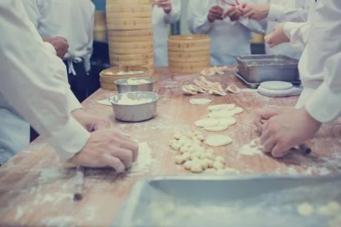 Dim Sum chefs working wrapping dumplings at famous restaurant in Taiwan. Stock Photos