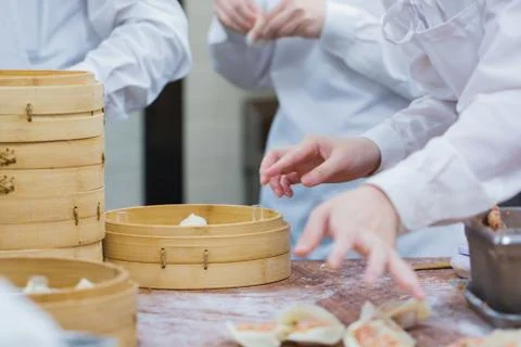 Dim Sum chefs working wrapping dumplings at famous restaurant in Taiwan. Stock Photos