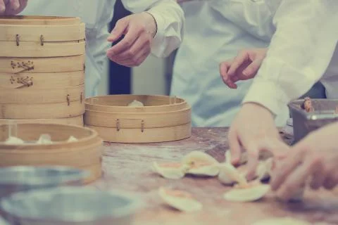 Dim Sum chefs working wrapping dumplings at famous restaurant in Taiwan. Stock Photos