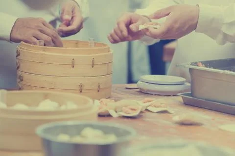 Dim Sum chefs working wrapping dumplings at famous restaurant in Taiwan. Stock Photos