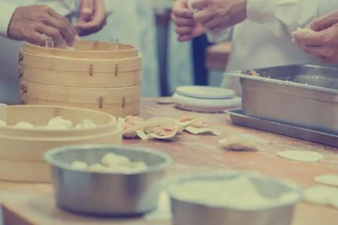 Dim Sum chefs working wrapping dumplings at famous restaurant in Taiwan. Stock Photos