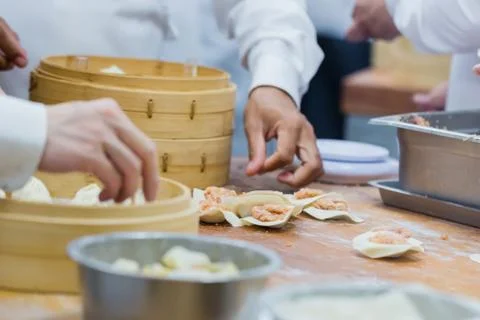 Dim Sum chefs working wrapping dumplings at famous restaurant in Taiwan. Stock Photos