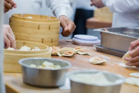 Dim Sum chefs working wrapping dumplings at famous restaurant in Taiwan. Stock Photos