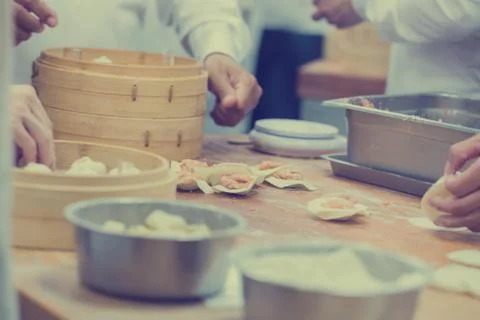 Dim Sum chefs working wrapping dumplings at famous restaurant in Taiwan. Stock Photos