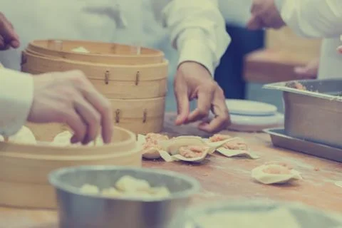Dim Sum chefs working wrapping dumplings at famous restaurant in Taiwan. Stock Photos