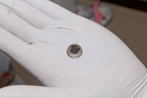 The dime-size microchip in this close-up image carries 826,923 names that ... Foto stock