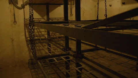 A dimly lit bunk room with bunk beds suspended by chains. Bunk room underground Vídeo Stock 301031506