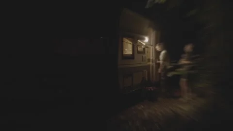 A dimly lit cabin, enveloped by dense foliage and shifting shadows, evokes a Stock Footage 304683074