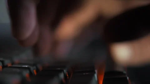 In a dimly lit coding studio fingers fly across a keyboard as a programmer r Stock Footage 331475392
