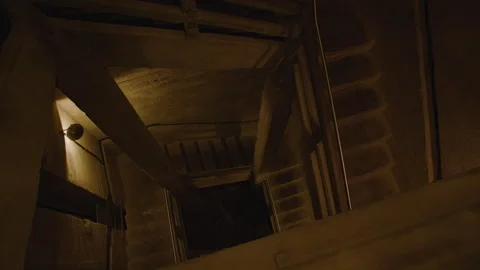 A dimly lit concrete stairwell with sharp angles, steel railings, and exp Stock Footage 301030262