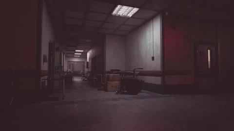 Dimly lit hospital corridor with empty equipment and scattered boxes at night Stock Footage 321351807