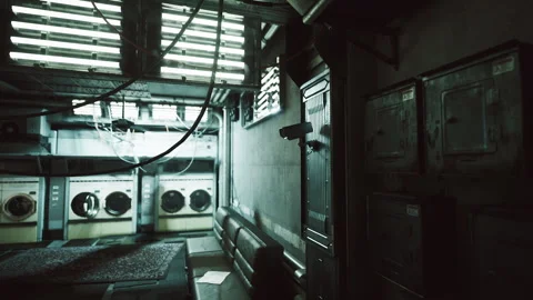 Dimly lit laundry room featuring old machines and cables in an urban setting Video stock 310264830