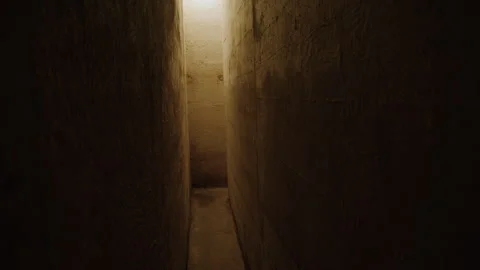 A dimly lit narrow corridor with rough walls leading to a dead-end Stock Footage 301034248