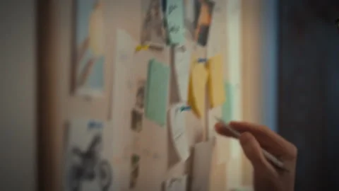 In a dimly lit office a man methodically plans his work tasks using a whiteb Stock Footage 331461483