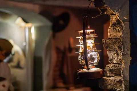 Dimly lit setting, rustic charm, wall-mounted lantern, generatordynamo, wires Stock Photos