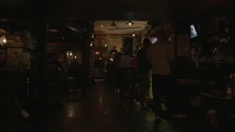 Dimly Lit Tavern Interior with Patrons and Live Music Stock Footage 343951564