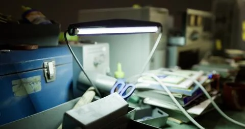 Dimly lit workspace filled with tools and materials at night Stock Illustration