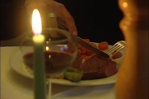 Diner Cutting Steak at Candlelit Table Stock Footage 121603228