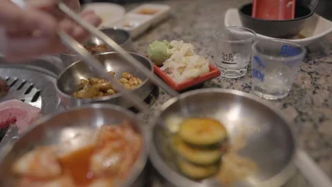Diner picks banchan from plates Stock Footage 305791594