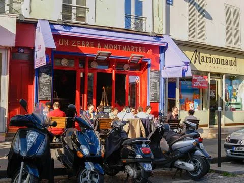 Diners in setting sun at outdoor pavement cafe in Montmatre Stock Photos