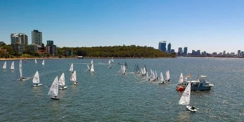 Dinghy regatta lining up for a start in front of Perth City Stock Photos
