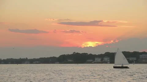 A dinghy sails by at Sunset Video stock 12522251