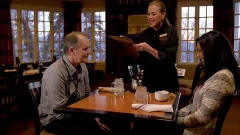 Dining 2 guests being served apps pan right to left Stock Footage 105319978