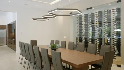 Dining area adjacent to wine storage display. Long wooden table with multiple Stock Footage 294906834
