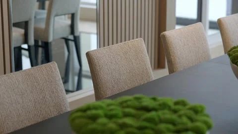 Dining area with beige textile chairs standing in row by long dark plain table Stock Footage 265201461