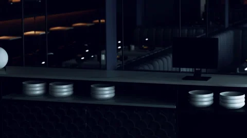 Dining area with empty bowls and a computer screen at night Stock Footage 343935654