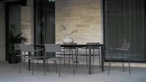 Dining area with a large table and lots of chairs in front of a private house Stock Footage 220773497