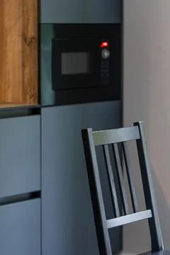 Dining chair in a modern kitchen. Dark cabinets blur behind. Stock Photos
