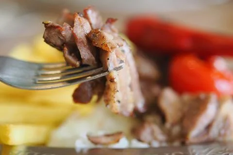 Dining experience with fork holding grilled meat Stock Photos