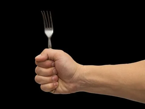 Dining fork in hand on a black background Stock Photos