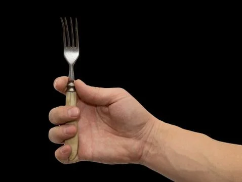 Dining fork in hand on a black background Foto stock
