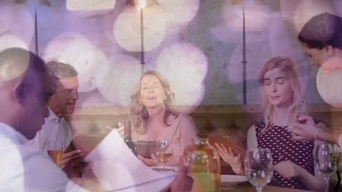 Dining group using menus and tablets in restaurant, server approaching, taking Stock Footage 333949827