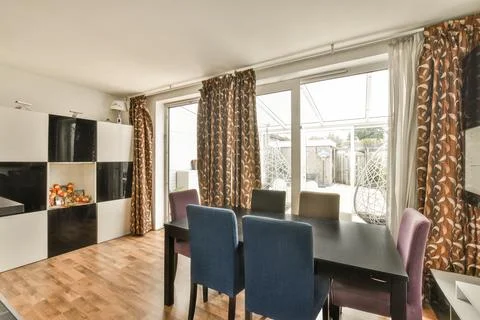 A dining room with a black dining table and chairs Stock Photos