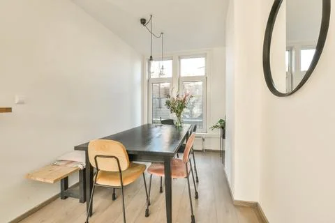 A dining room with a long black table and chairs 写真素材