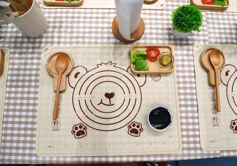 Dining setup with bear-themed placemats and utensils at a restaurant Stock Photos