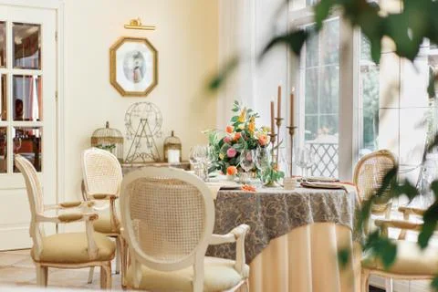 A dining table and comfortable armchairs in a modern house with a light dining Stock Photos