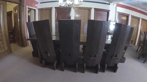 Dining table and high back chairs lines in a row view from behind lower angle.  Stock Footage 97226182