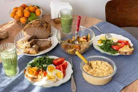 On a dining table, breakfast includes a boiled egg with arugula and tomato,.. Stock Photos