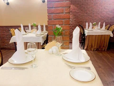 The dining table is covered with a white tablecloth, there are appliances on the Stock Photos